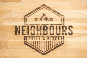 Neighbours logo op hout